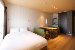 a bedroom with a bed and a desk and a table at 5 minutes Shin-Osaka 9 in Osaka