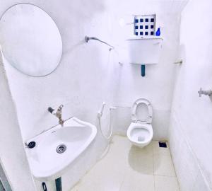 a bathroom with a sink and a toilet and a mirror at Himali Niwasa in Matara
