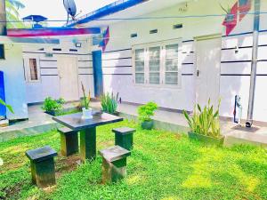 a patio with a table and benches in front of a building at Himali Niwasa in Matara