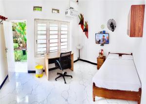 a bedroom with a bed and a desk and a computer at Himali Niwasa in Matara