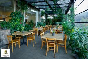 a restaurant with tables and chairs and plants at Marabedda Gardens Resort in Rikillagaskada