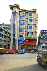 a large building with cars parked in front of it at Mannars Yatri Nivas Hotel in Mysore