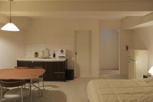a room with a bed and a table and a kitchen at 버터인 강릉역 중앙시장 월화거리 교리단길 도보 10분 in Gangneung
