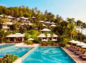 a resort swimming pool with chairs and umbrellas at Salad Buri Resort- SHA Extra Plus in Salad Beach