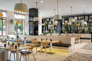 a restaurant with tables and chairs and a bar at INNSiDE by Meliá Leipzig in Leipzig