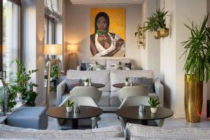 a restaurant with tables and a couch and a painting at INNSiDE by Meliá Leipzig in Leipzig