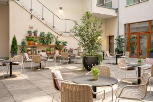 an outdoor patio with tables and chairs and plants at INNSiDE by Meliá Leipzig in Leipzig +45 photos
