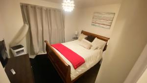 a small bedroom with a bed with a red blanket at Tree bedrooms in Salt Lake City