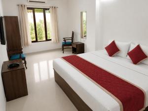 a bedroom with a large bed and a chair at Beach Resort in 1 in North goa