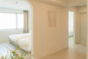 a bedroom with a bed and a mirror at 버터인 강릉역 중앙시장 월화거리 교리단길 도보 10분 in Gangneung