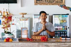 a man standing in front of a counter doing a gesture at Dream Beach Kubu & SPA by ABM in Nusa Lembongan