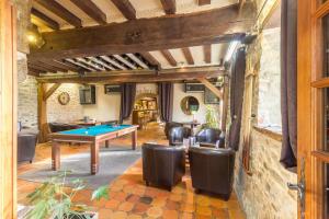 a living room with a ping pong table and leather chairs at Logis Hotel Oasis in Villaines-la-Juhel
