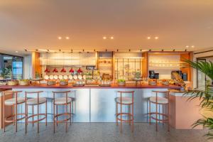 a kitchen with a bar with stools at INNSiDE by Meliá Crete Elounda in Elounda