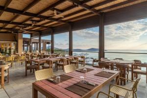 a restaurant with tables and chairs and a view of the ocean at INNSiDE by Meliá Crete Elounda in Elounda