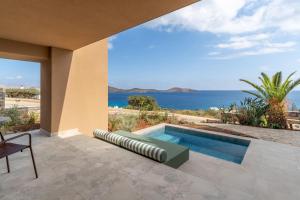a swimming pool with a view of the ocean at INNSiDE by Meliá Crete Elounda in Elounda