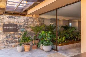 a lobby with a bunch of potted plants at INNSiDE by Meliá Crete Elounda in Elounda +108 photos