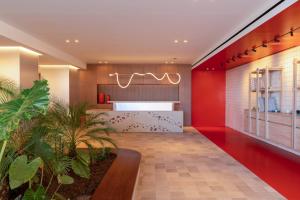 a lobby with a red wall and a counter at INNSiDE by Meliá Crete Elounda in Elounda