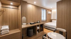 a room with a bed and a desk with a mirror at 에이치에비뉴 상주터미널점 in Sangju +30 photos