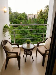 a balcony with two chairs and a table and a window at Beach Resort in 1 in North goa +5 photos