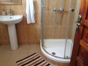 a bathroom with a shower and a sink at Benconi Lodge in Accra
