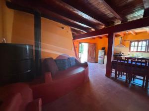 a living room with a red couch and a kitchen at Comarca del Hobit in Yala