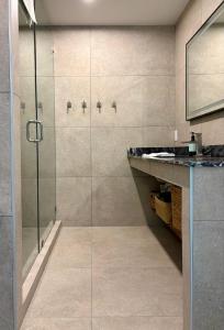 a bathroom with a glass shower and a sink at The Four Cedars in Ucluelet +23 photos