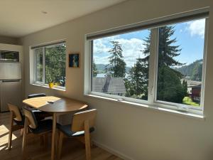 a dining room with a table and a large window at The Four Cedars in Ucluelet