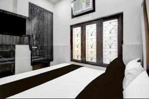 a bedroom with a large bed and a window at Hotel Birhana road in Kānpur