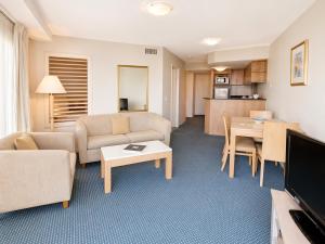 a living room with a couch and a table at Landmark Resort Mooloolaba 4th Floor Apartment with a View in Mooloolaba