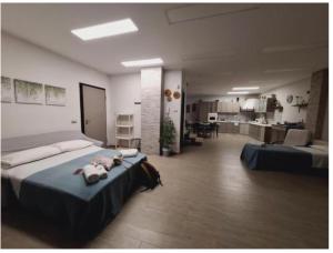 a large room with a bed and a kitchen at Le Mandorle Apartment in Belpasso