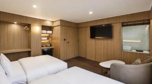 a hotel room with a bed and a tv at 에이치에비뉴 상주터미널점 in Sangju