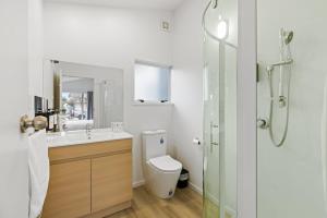 a bathroom with a toilet and a sink and a shower at Brookside Residence in Rolleston +9 photos