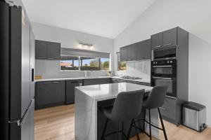 a kitchen with black cabinets and a white counter top at Brookside Residence in Rolleston