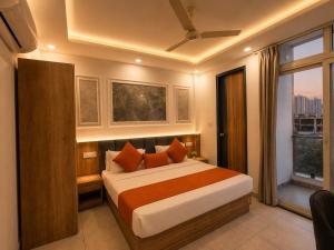 a bedroom with a bed with orange pillows and a window at Hotel Smart Snap Sector 104, Noida in Noida