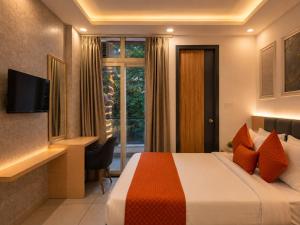 a hotel room with a bed and a desk and a window at Hotel Smart Snap Sector 104, Noida in Noida