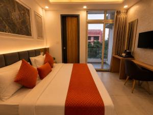 a hotel room with a large bed with orange pillows at Hotel Smart Snap Sector 104, Noida in Noida