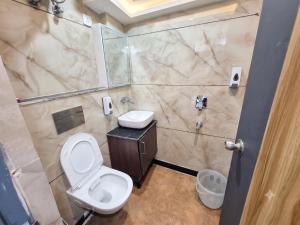 a bathroom with a toilet and a sink at Hotel Smart Snap Sector 104, Noida in Noida +15 photos