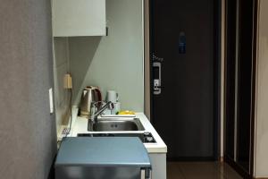 a kitchen with a sink and a counter top at Brown Suites Hotel Sinchon Central in Seoul +43 photos