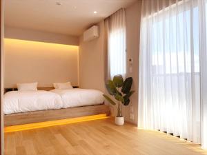 a bedroom with a bed and a large window at CONTEL BASE Tokyo in Tokyo