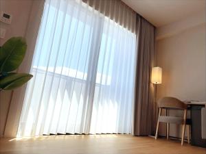a large window with white curtains in a room at CONTEL BASE Tokyo in Tokyo