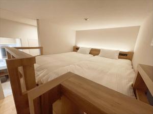 a small bedroom with two beds with white sheets at CONTEL BASE Tokyo in Tokyo +13 photos