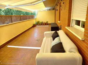 a living room with a couch on a balcony at Piso acogedor con terraza in Ciudad Real