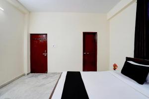 a bedroom with two red doors and a white bed at Hotel O Patel Nagar Patna Formerly Princess Home in Patna +31 photos