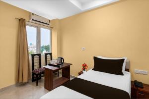 a bedroom with a bed and a table and a window at Townhouse Defence Colony Noida in Greater Noida