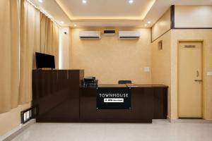 an office lobby with a desk with a townhouse sign on it at Townhouse Defence Colony Noida in Greater Noida