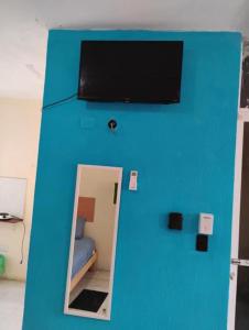 a blue wall with a tv on top of a room at Linda Vista Garden Cancun, Privado con AC y WiFi Cerca de Transporte a Zona Hotelera in Cancún