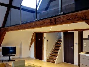 a loft conversion with a staircase and a living room at Historic Canal-Side Apartment in Schiedam