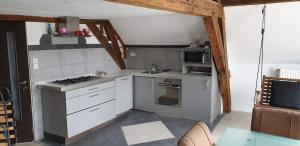 a kitchen with white cabinets and a stove top oven at Historic Canal-Side Apartment in Schiedam