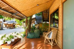 an open porch with chairs and potted plants at Sirem Beach Resort in Puerto Princesa City