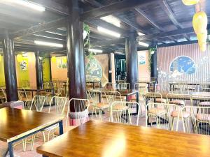 a restaurant with tables and chairs in a room at Woodstock Beach Camp in Cat Ba